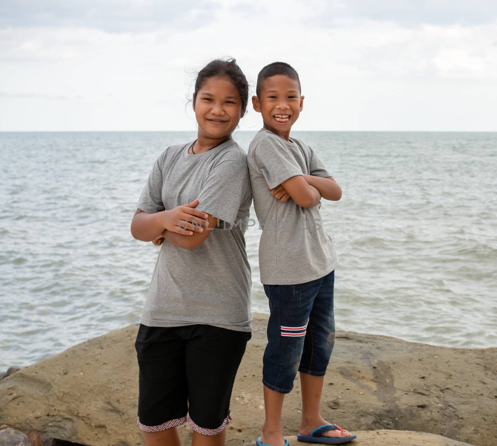 Sister and brother Stand on the sea background by Unimages2527