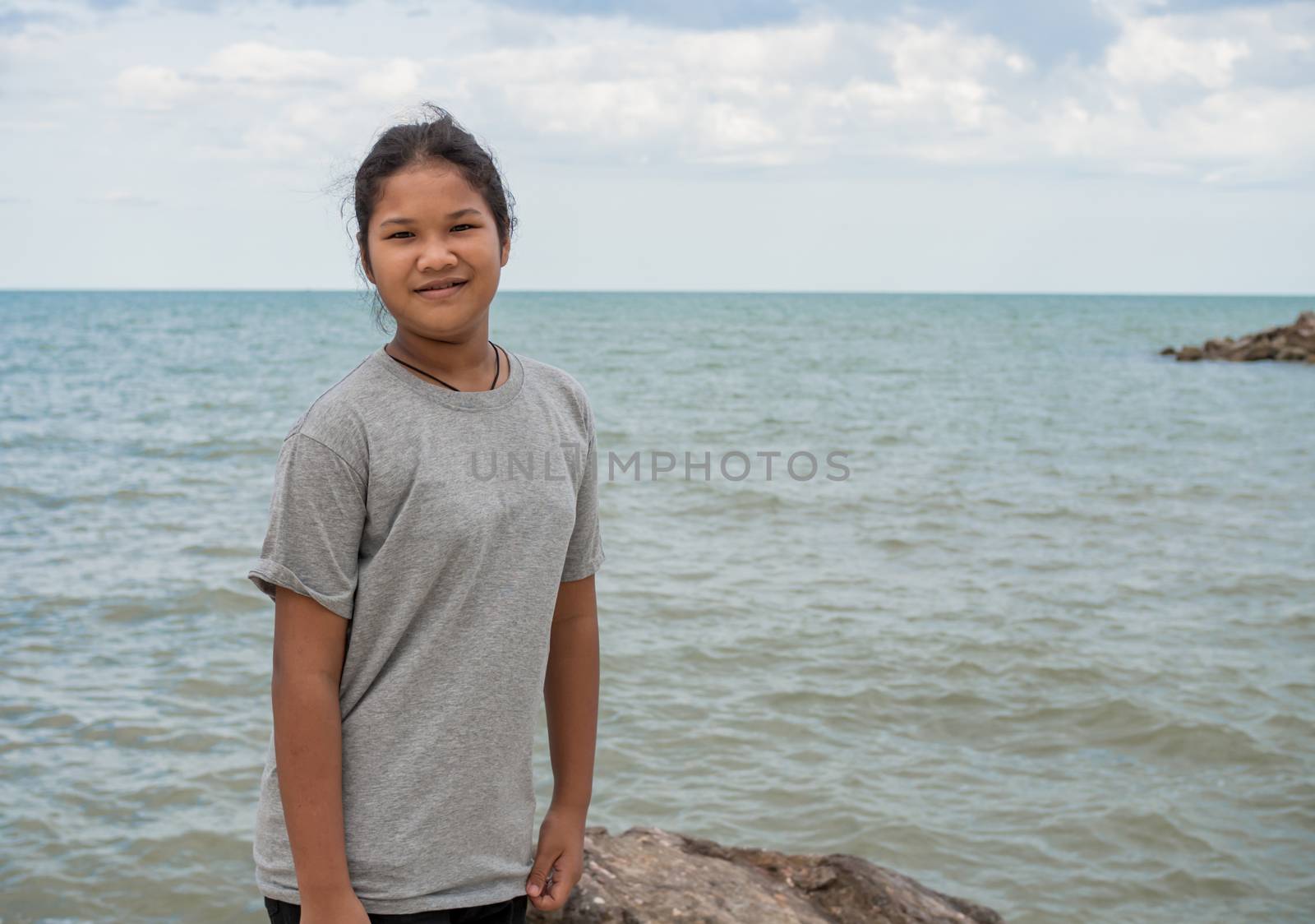 Portrait of a girl standing with a sea background. by Unimages2527