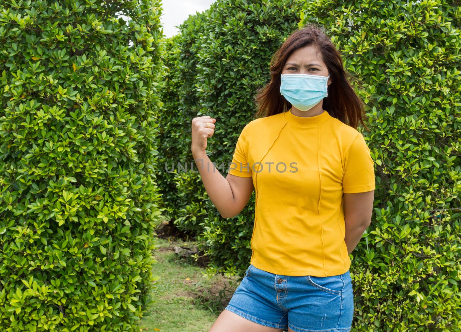 Portraits of women wearing protective masks During travel With a background of green trees