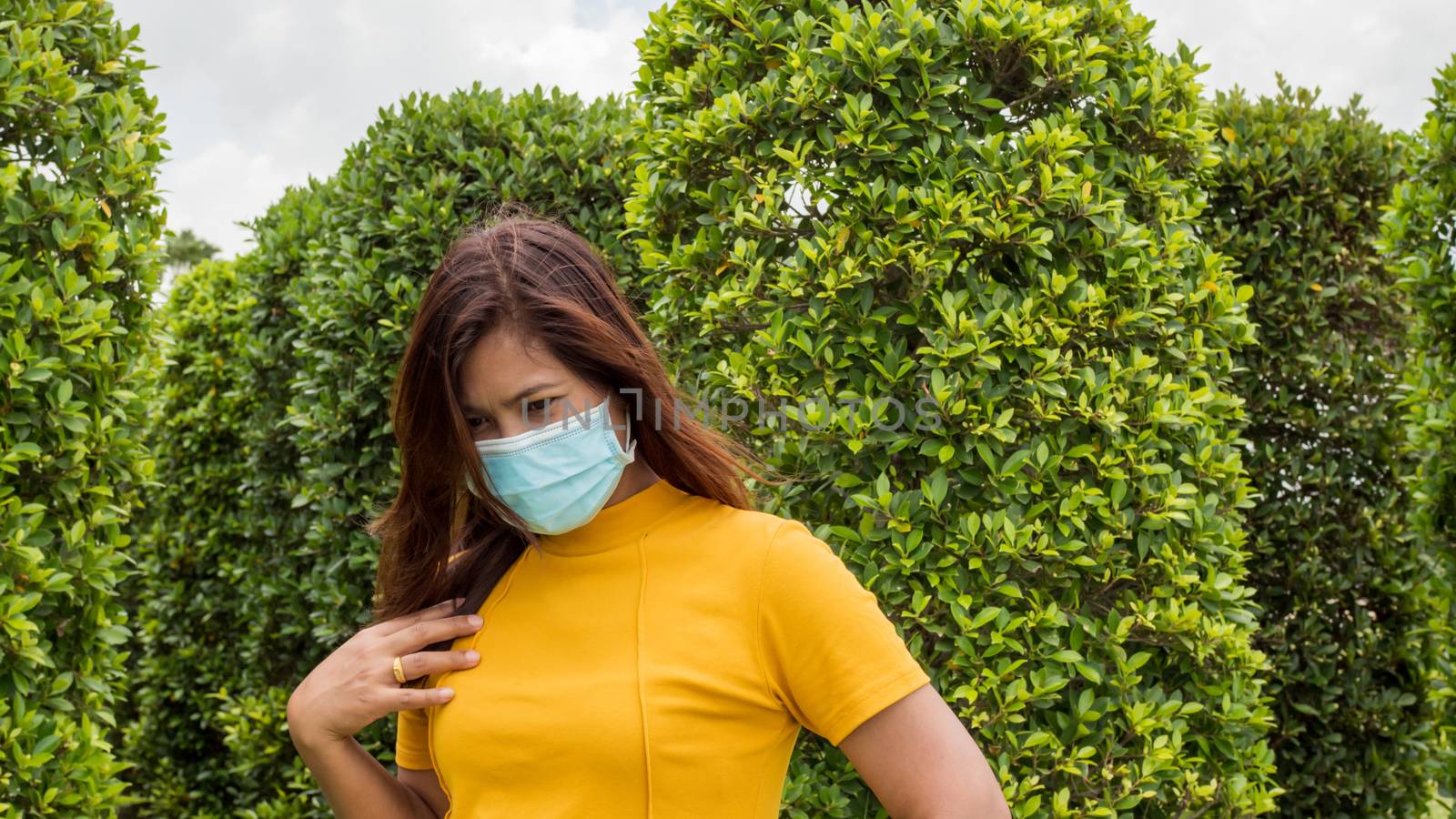 Portraits of women wearing protective masks During travel With a background of green trees