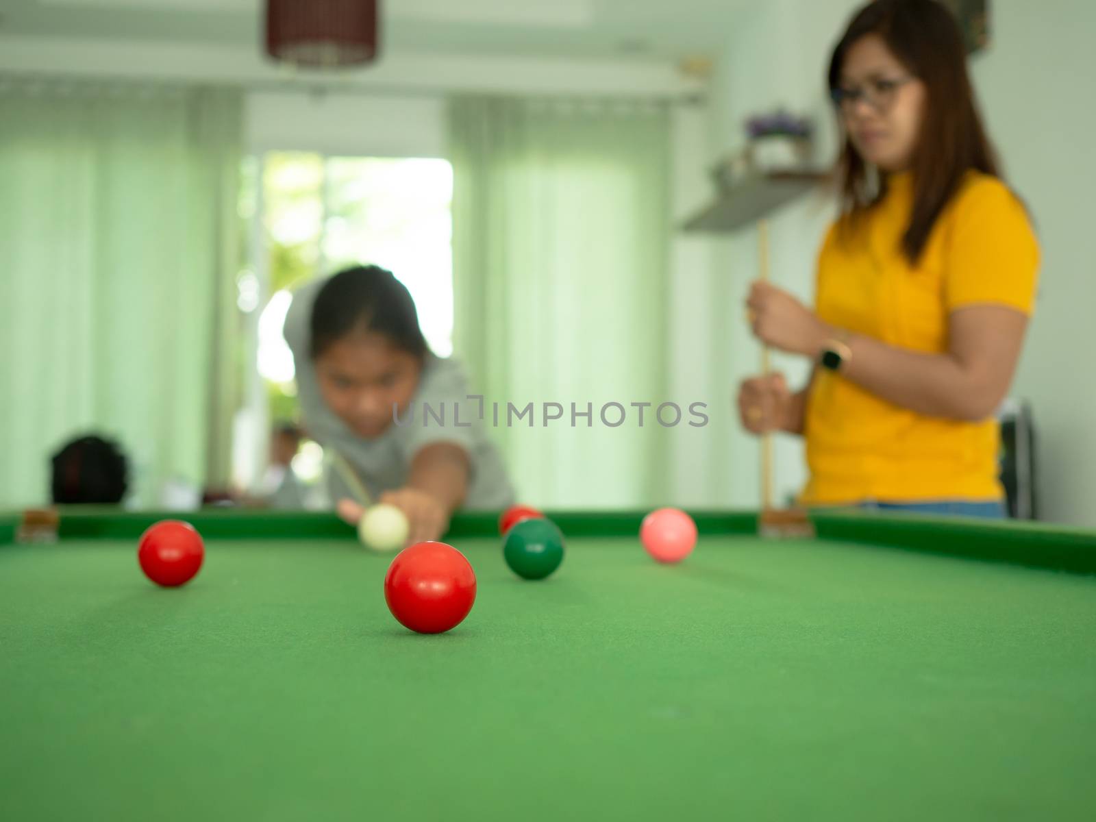 Red snooker ball On the background a person playing snooker. by Unimages2527