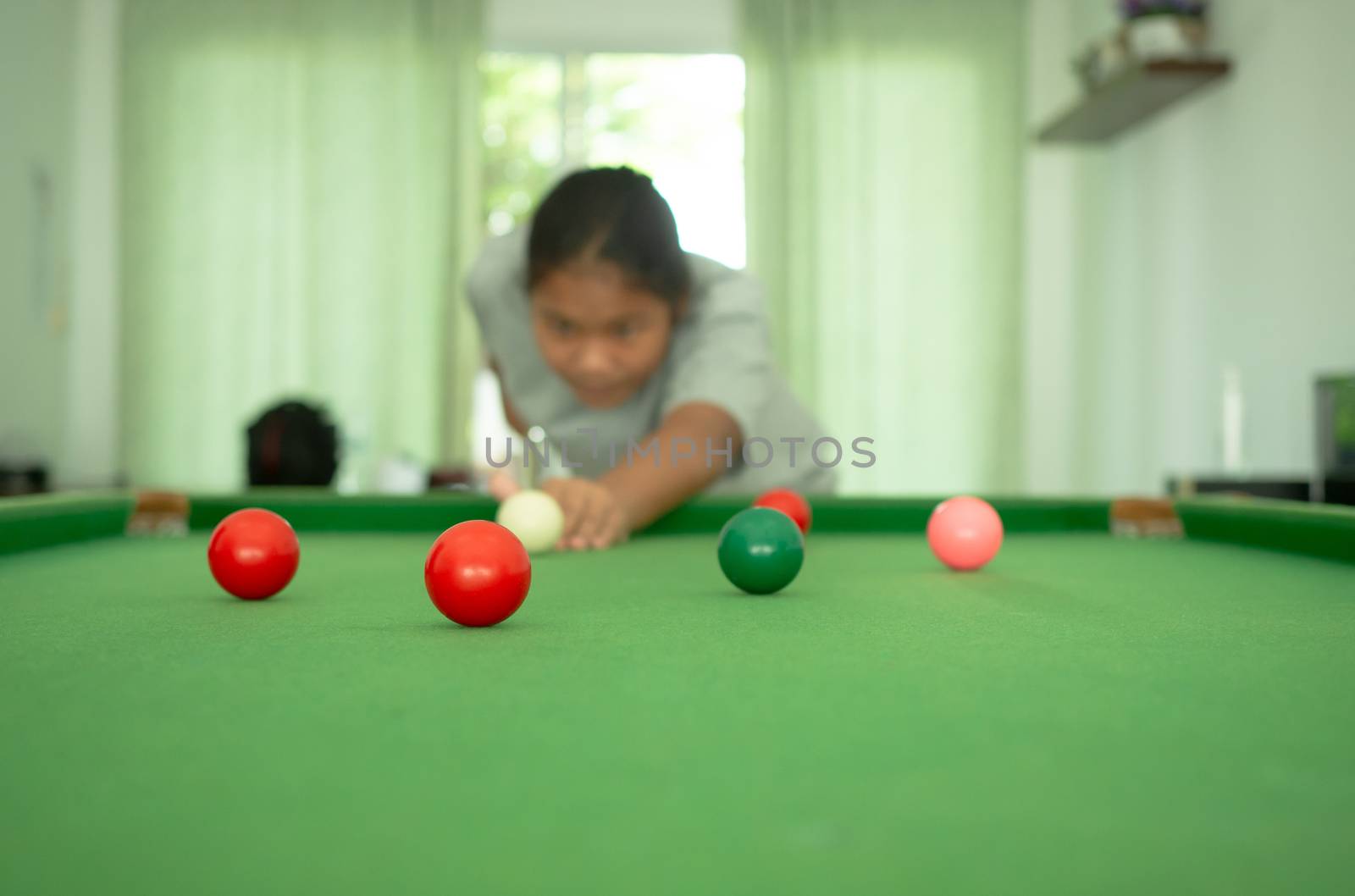 Red snooker ball On the background a person playing snooker. by Unimages2527