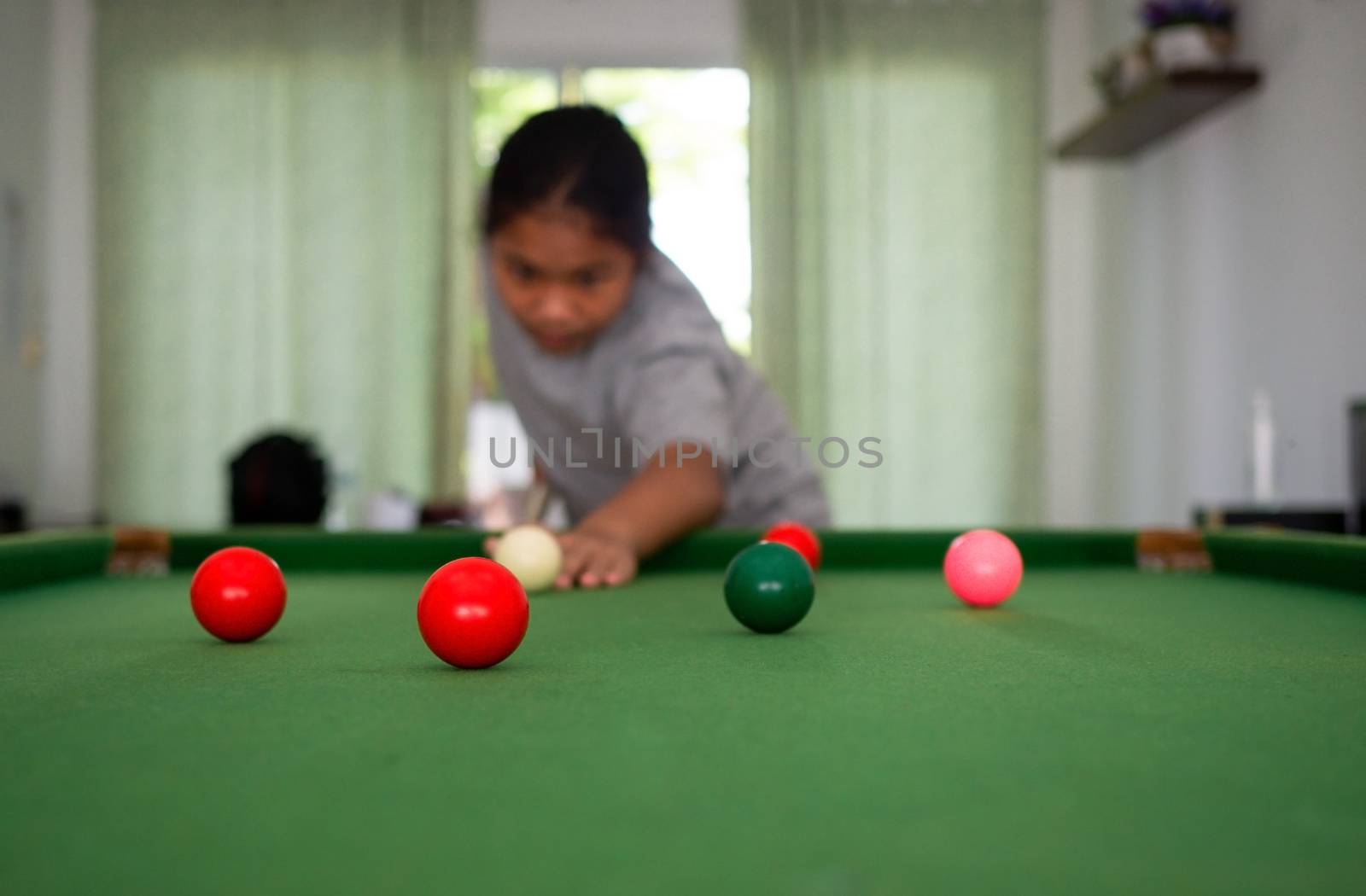 Asian woman playing snooker By aiming at his queue. Focus on the by Unimages2527