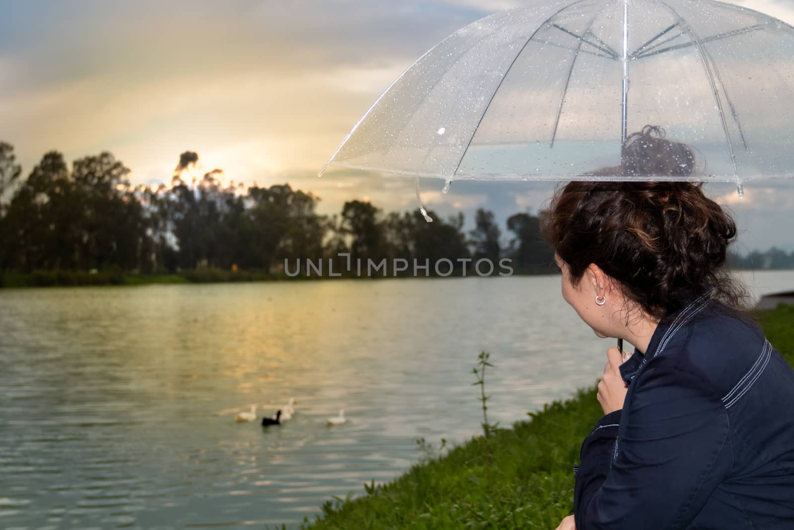 Real woman watching the sunset on a lake. by leo_de_la_garza