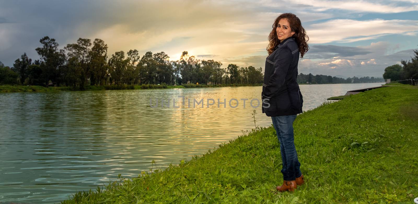Real woman watching the sunset on a lake. summer