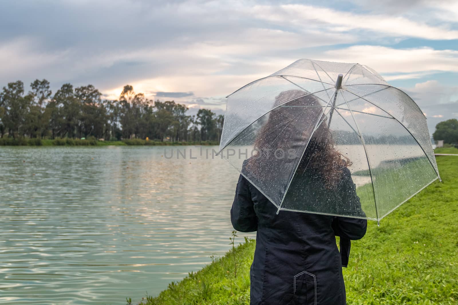 Real woman watching the sunset on a lake. summer