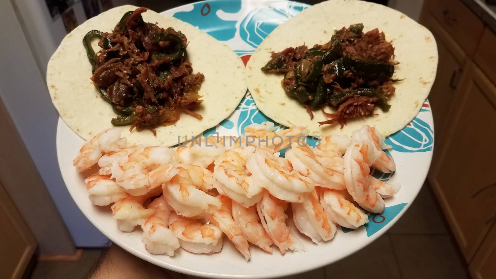 face with shrimp and pork tacos on plate in kitchen
