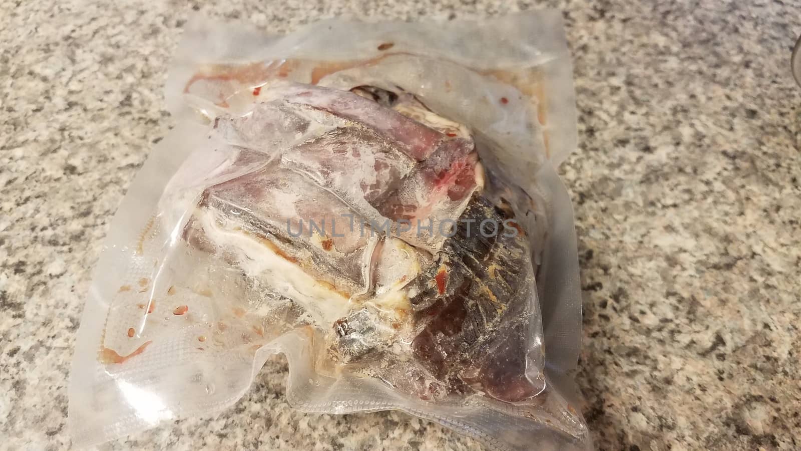 frozen raw beef meat in plastic bag on counter