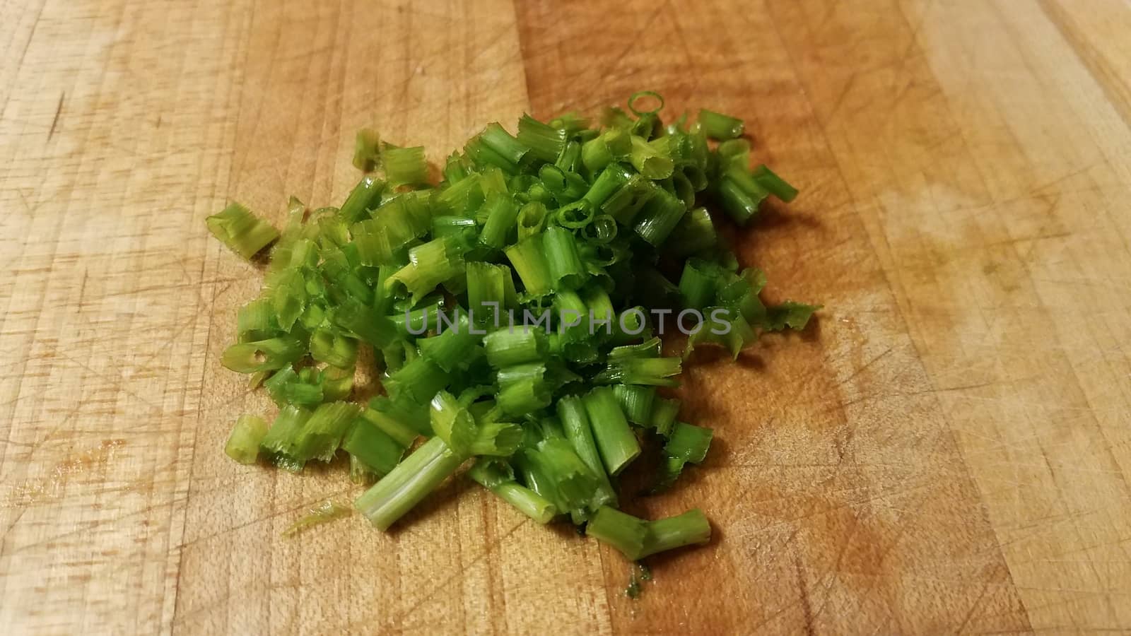 green chives or onions vegetables on wood cutting board