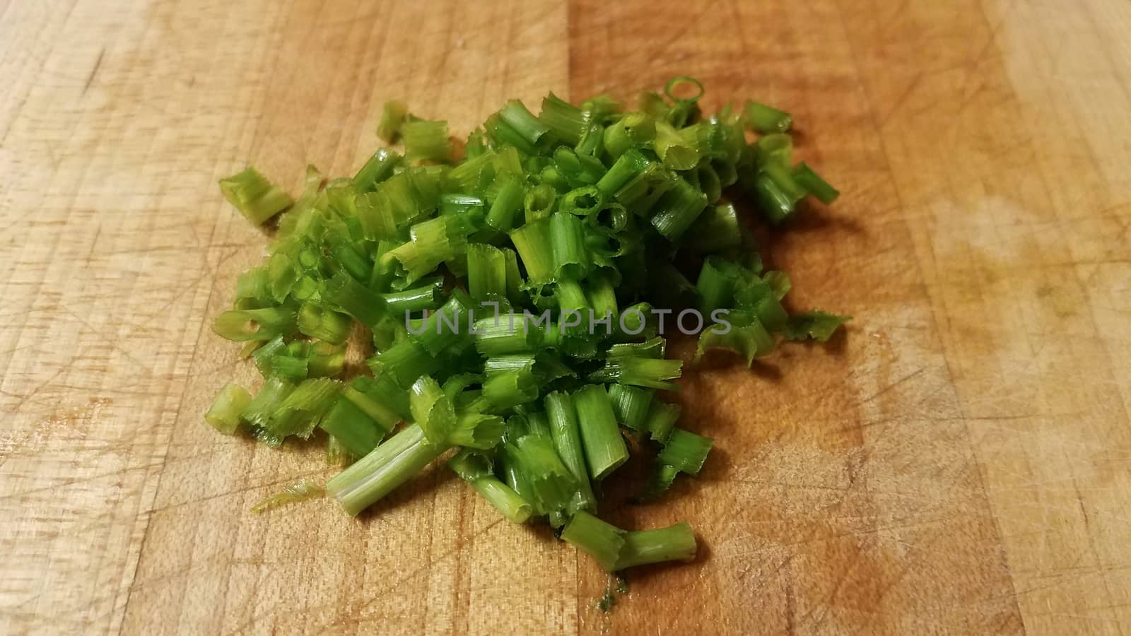 green chives or onions on wood cutting board by stockphotofan1