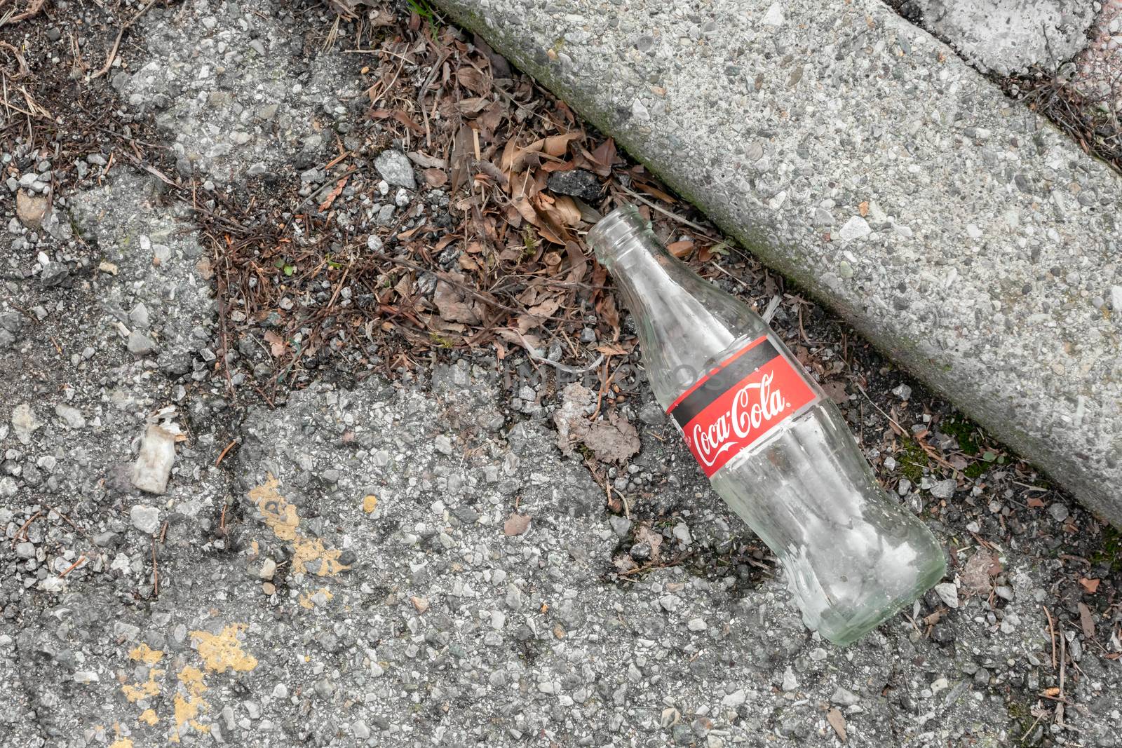 Empty bottle of Coca Cola on the ground. Bergamo, ITALY - February 19, 2020