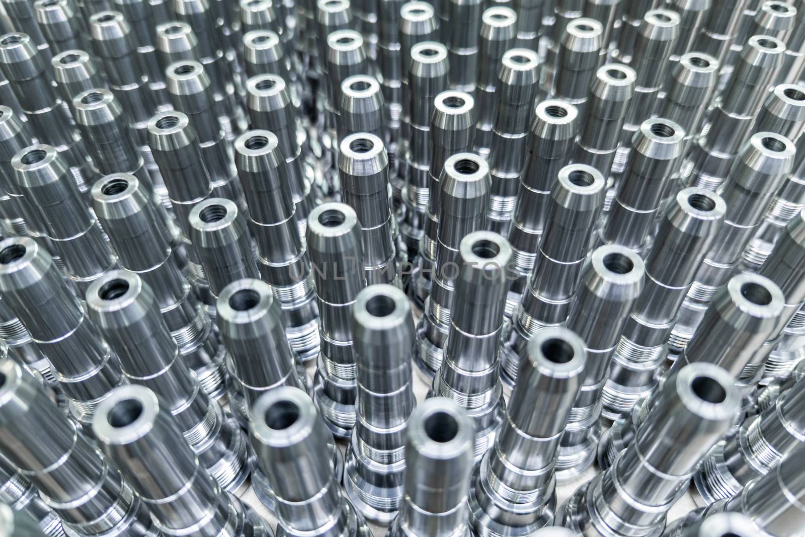 Shiny long steel parts full frame background, clean steel threaded rods after fine cnc turning.