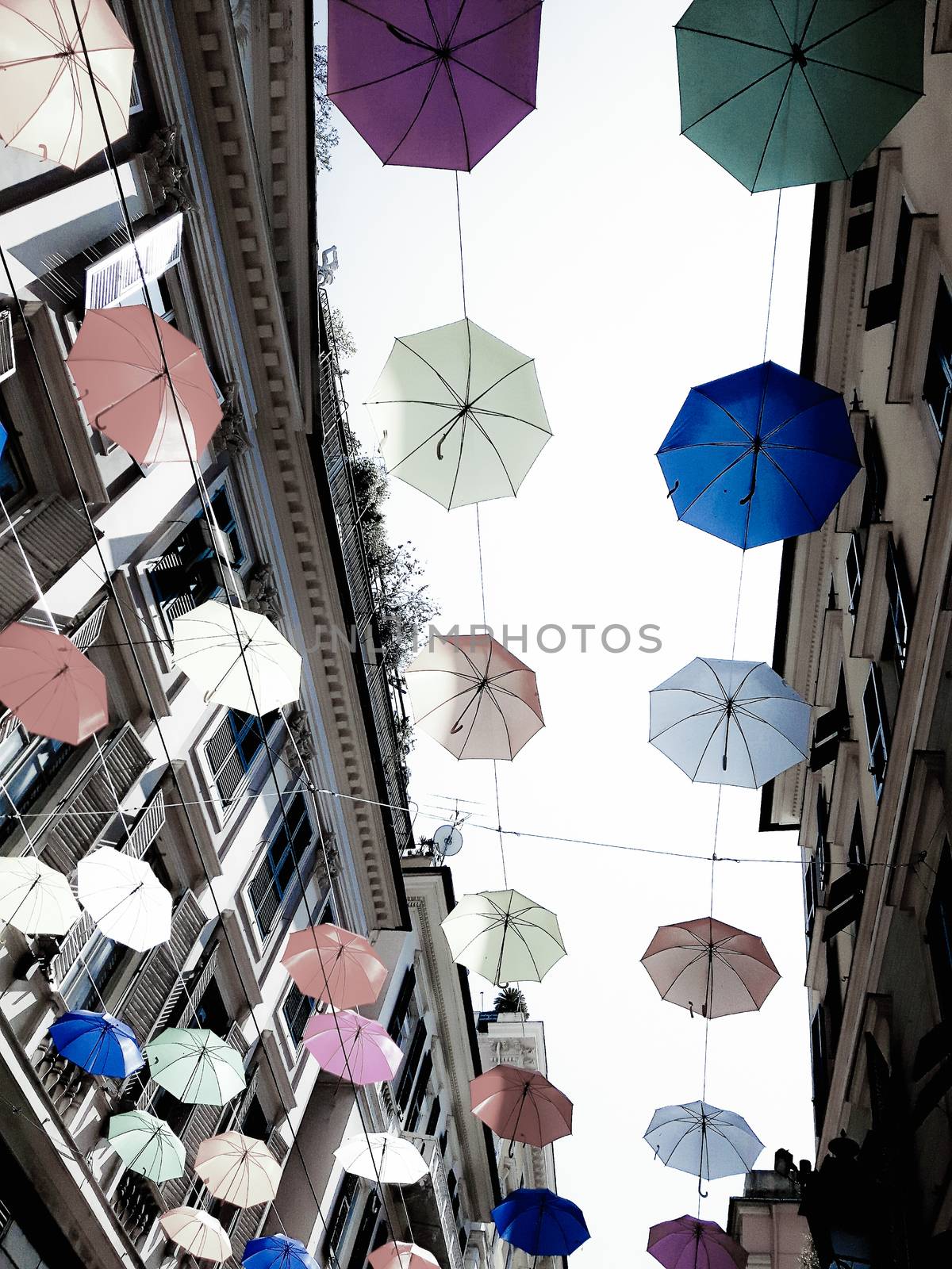 Genova, Italy - 0/29/2020: Multicolored umbrellas against the sky, street decorated. LGBT flag. Rainbow love concept. Human rights and tolerance.