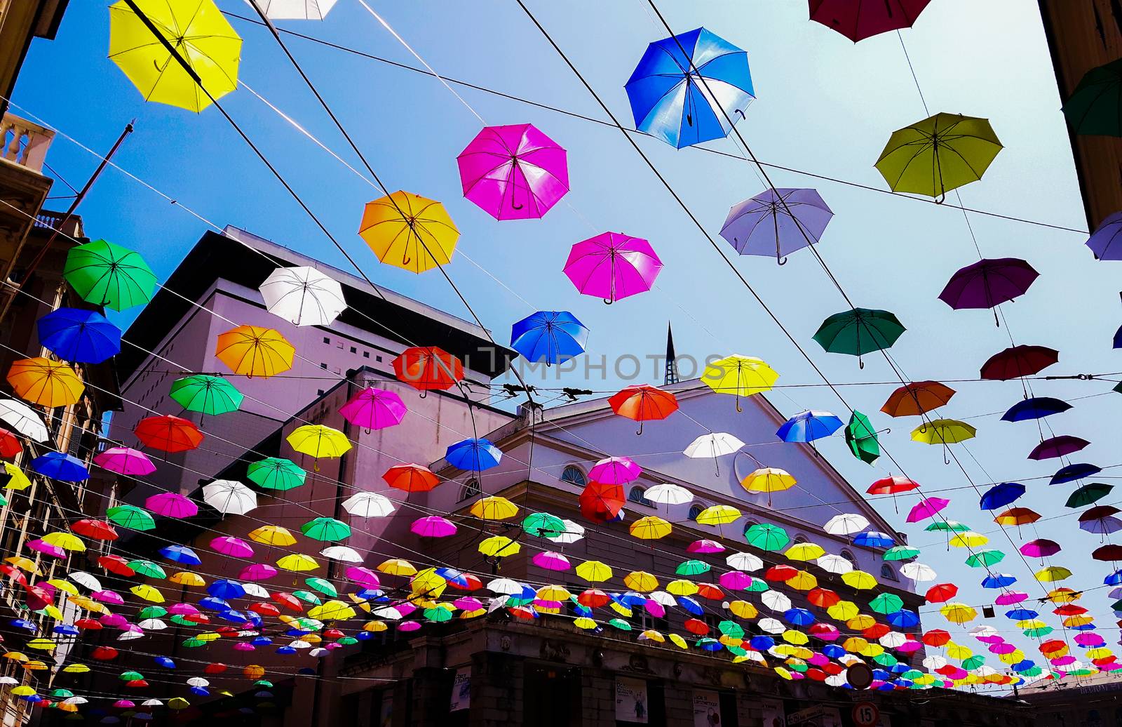 Genova, Italy - 0/29/2020: Multicolored umbrellas against the sky, street decorated. LGBT flag. Rainbow love concept. Human rights and tolerance.