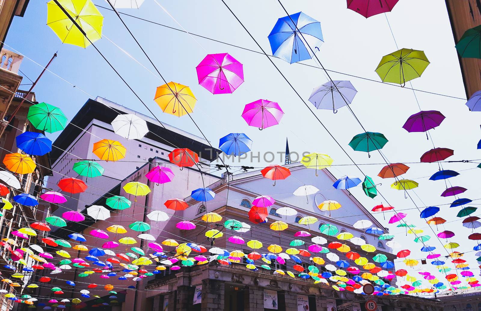 Genova, Italy - 0/29/2020: Multicolored umbrellas against the sky, street decorated. LGBT flag. Rainbow love concept. Human rights and tolerance.