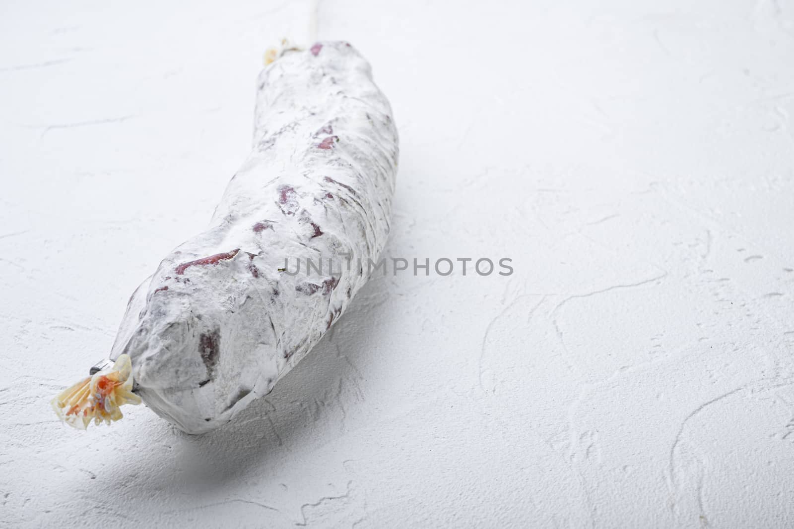Salami sausage salchichon on white background with space for text.
