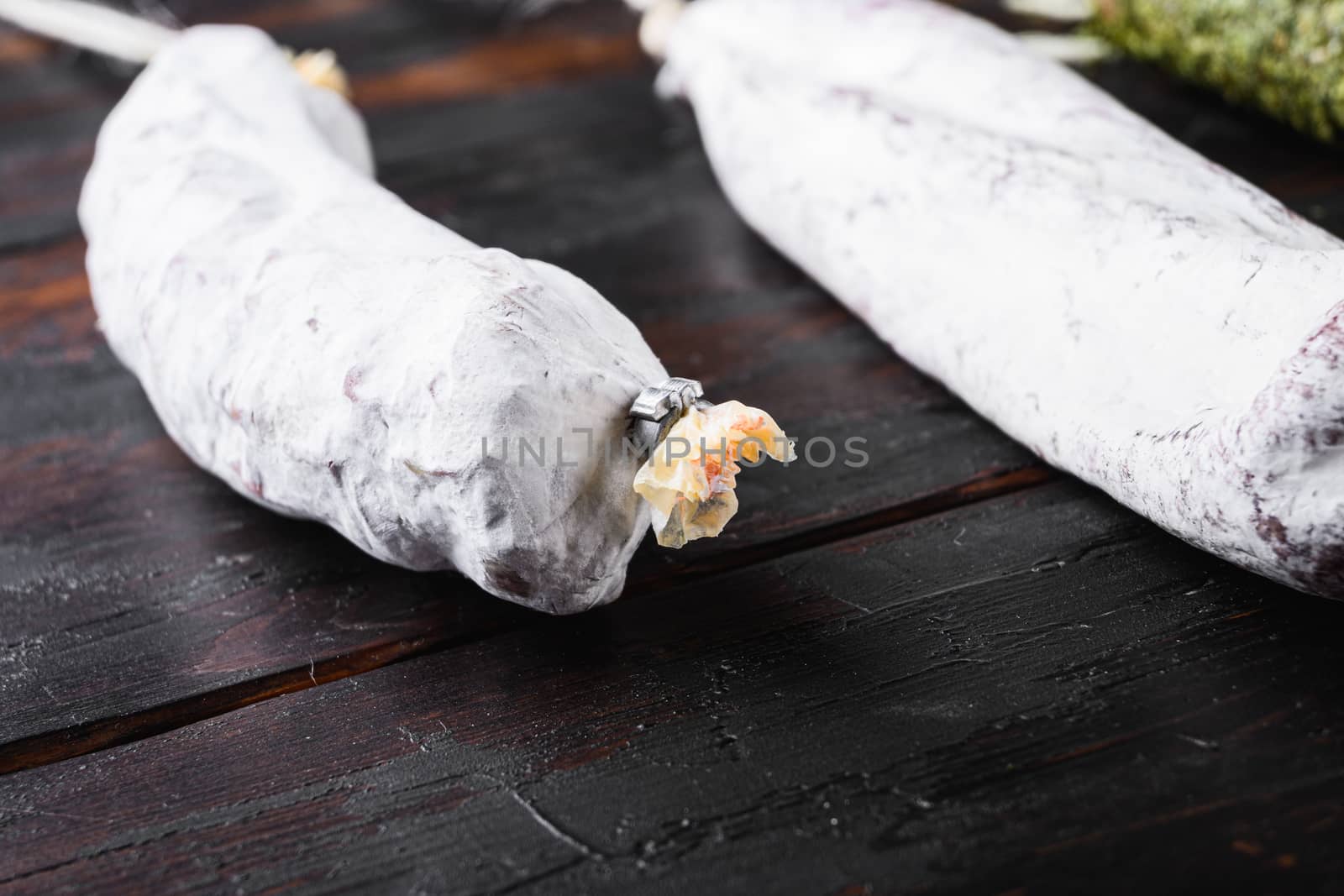 Spanish dry sausages on old wooden table.