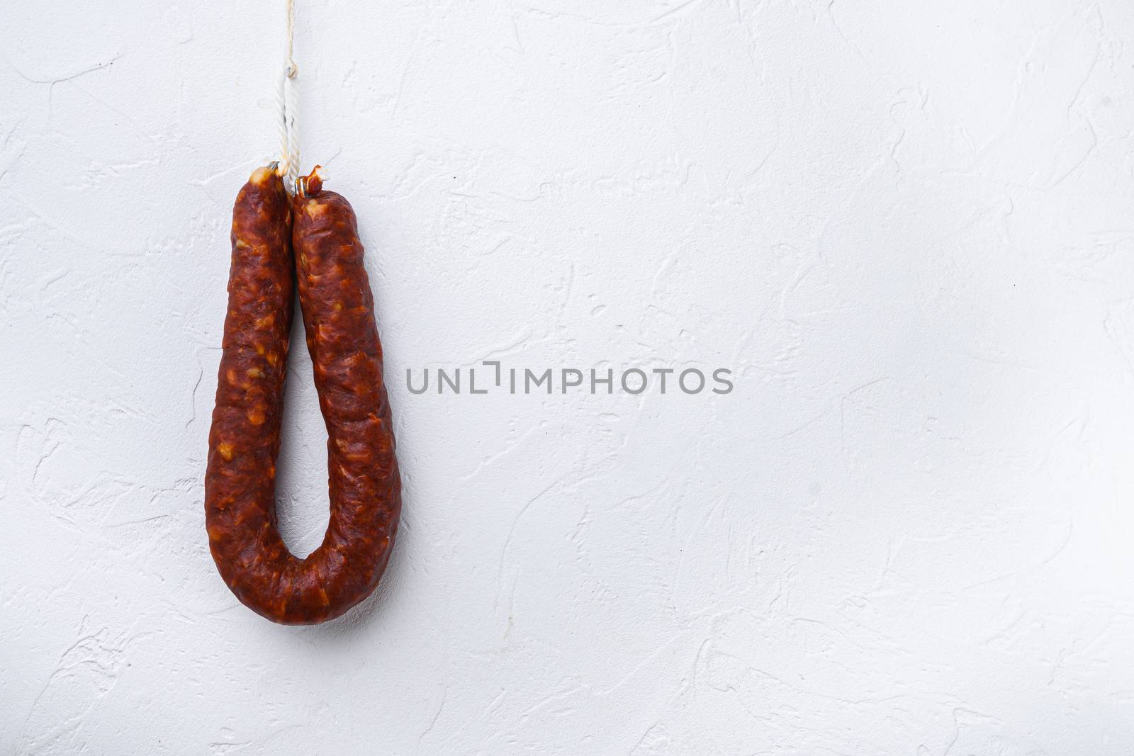 Spanish chorizo sausage on white background with space for text.