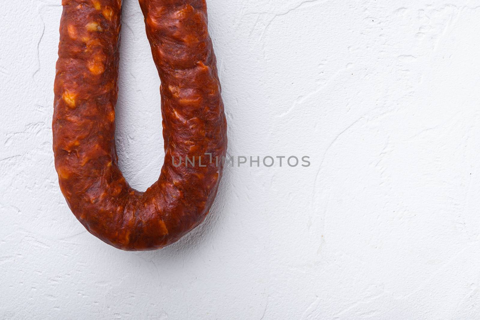 Spanish chorizo sausage on white background with space for text.