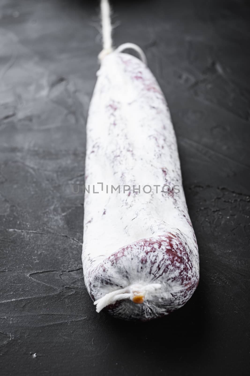 Spanish traditional longaniza sausage on black surface.