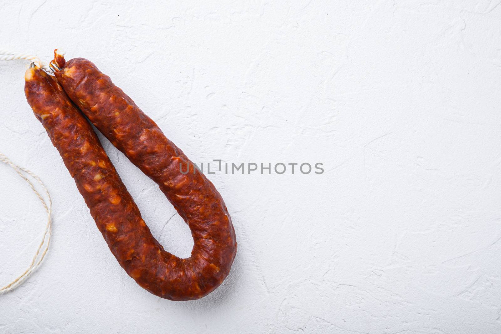 Spanish chorizo sausage on white background, topview with space for text.