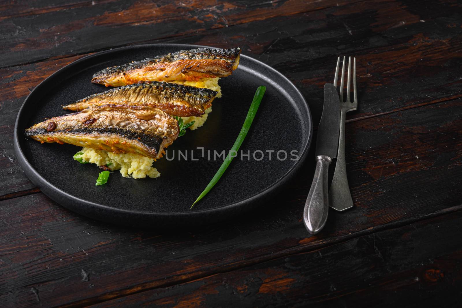 Amazing dish of marinated mackerel with garlic paprika and saffron.with softly mashed potatoes on dark wooden table.