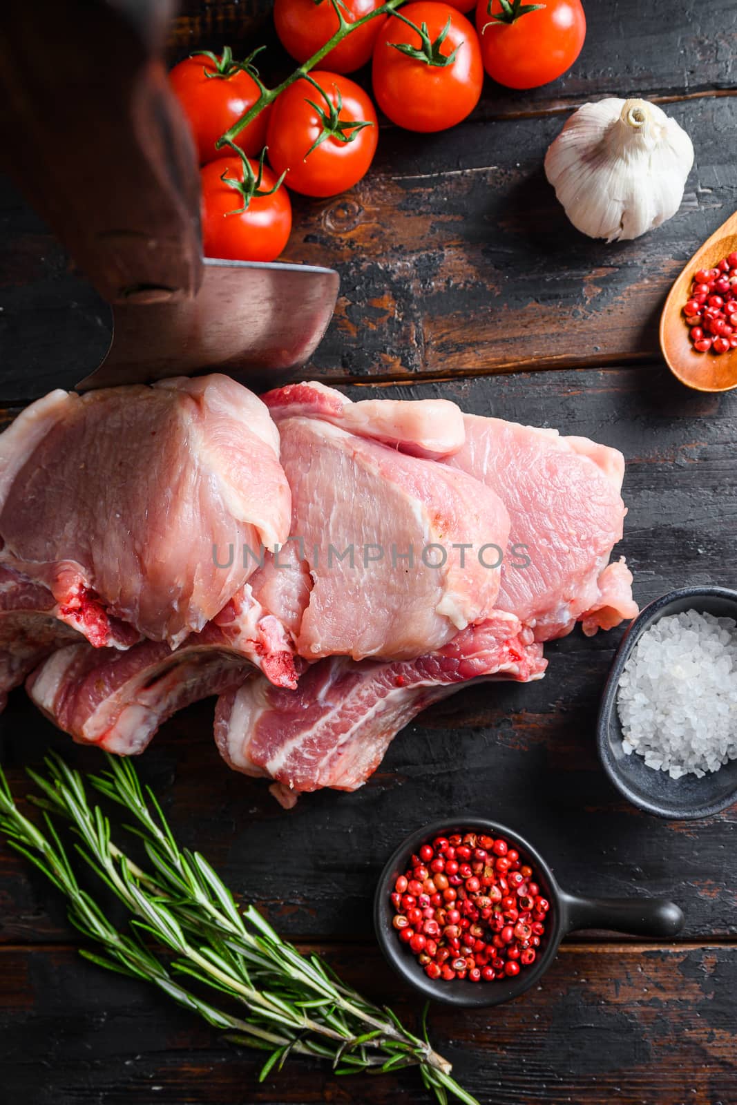 set organic pork chop steaks over dark background wood and rustic steel, close up selective focus top view. by Ilianesolenyi