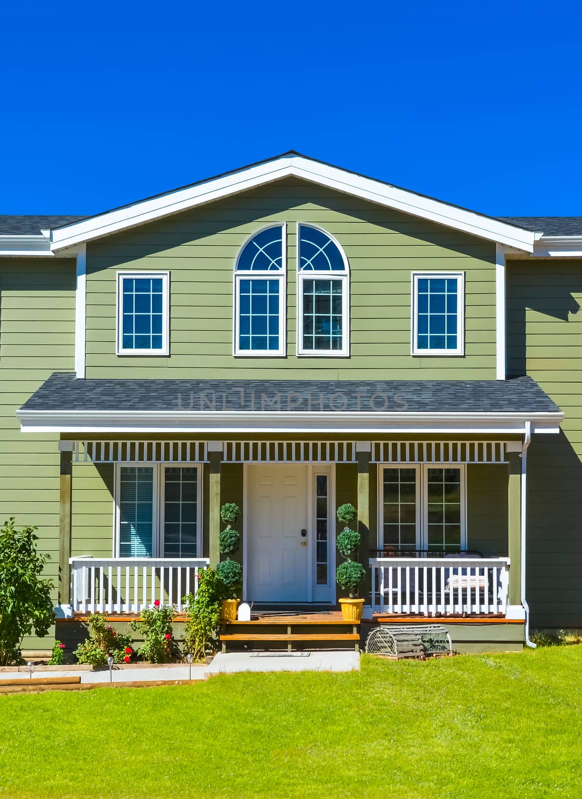 Entrance of residential house with door steps in front and blue sky background. British Columbia, Canada.