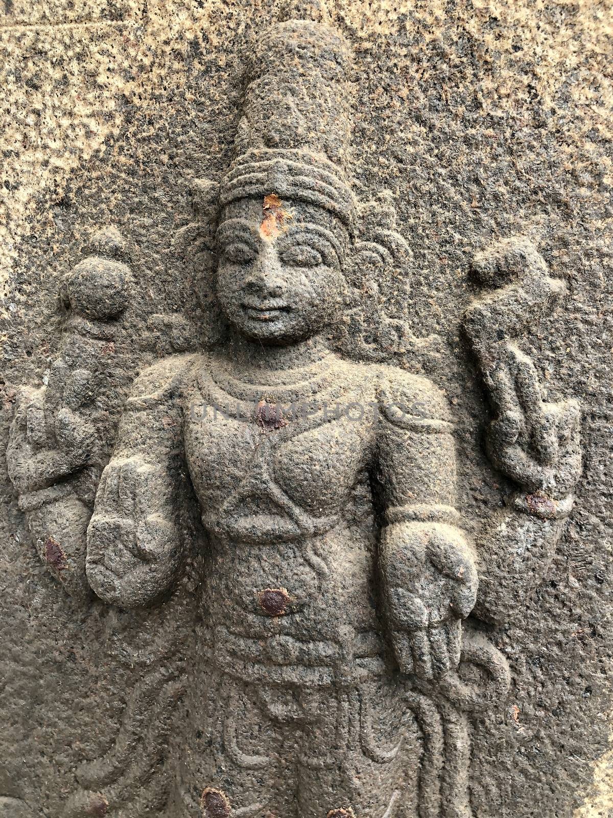 God standing with four hands sculpture. Bas relief sculpture carved in the walls of Shiva temple at Tamil nadu by prabhakaran851