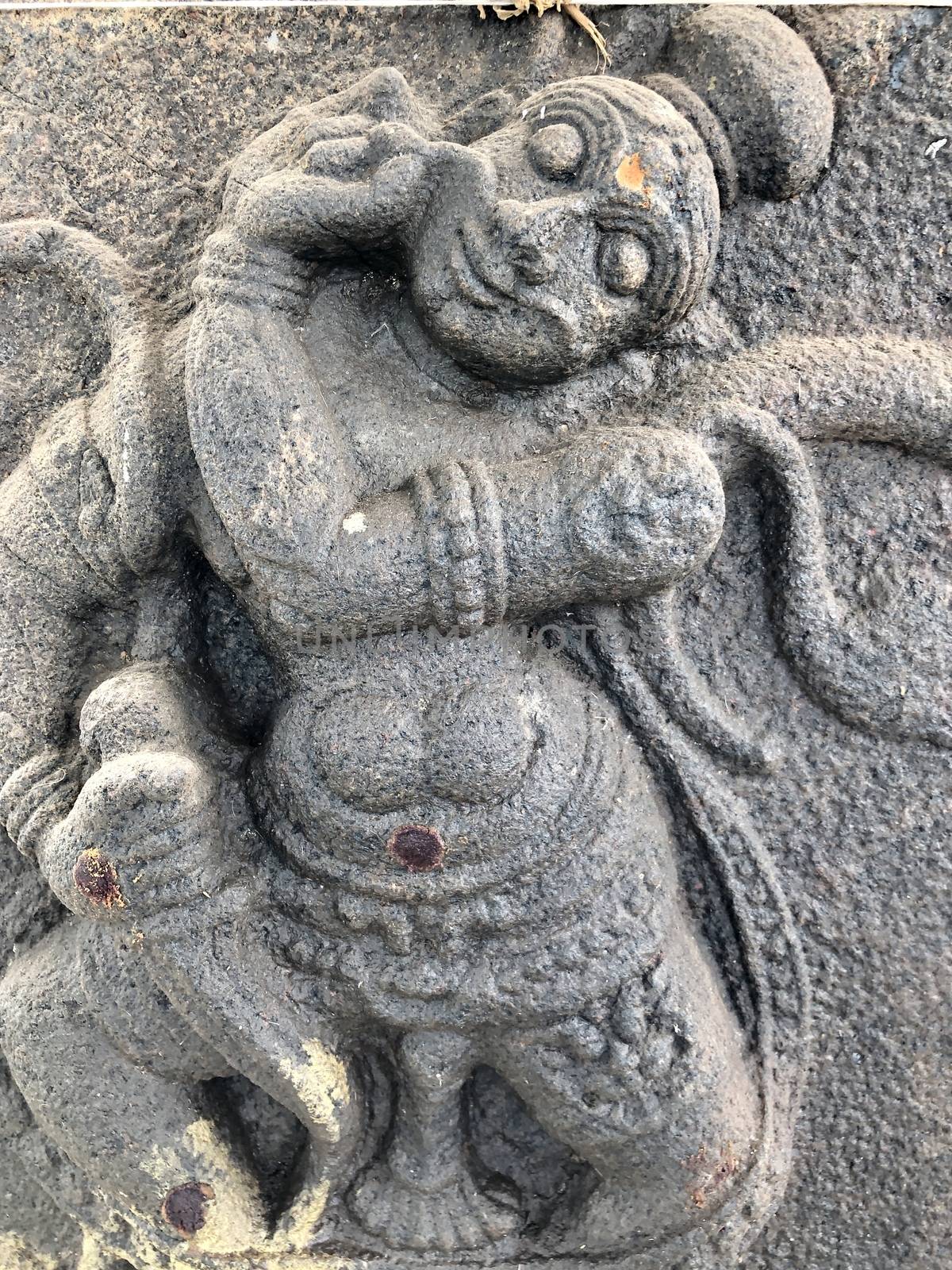 God statue with weapons in hand sculpture. Bas relief sculpture carved in the stone walls of Shiva temple, Tamil nadu by prabhakaran851