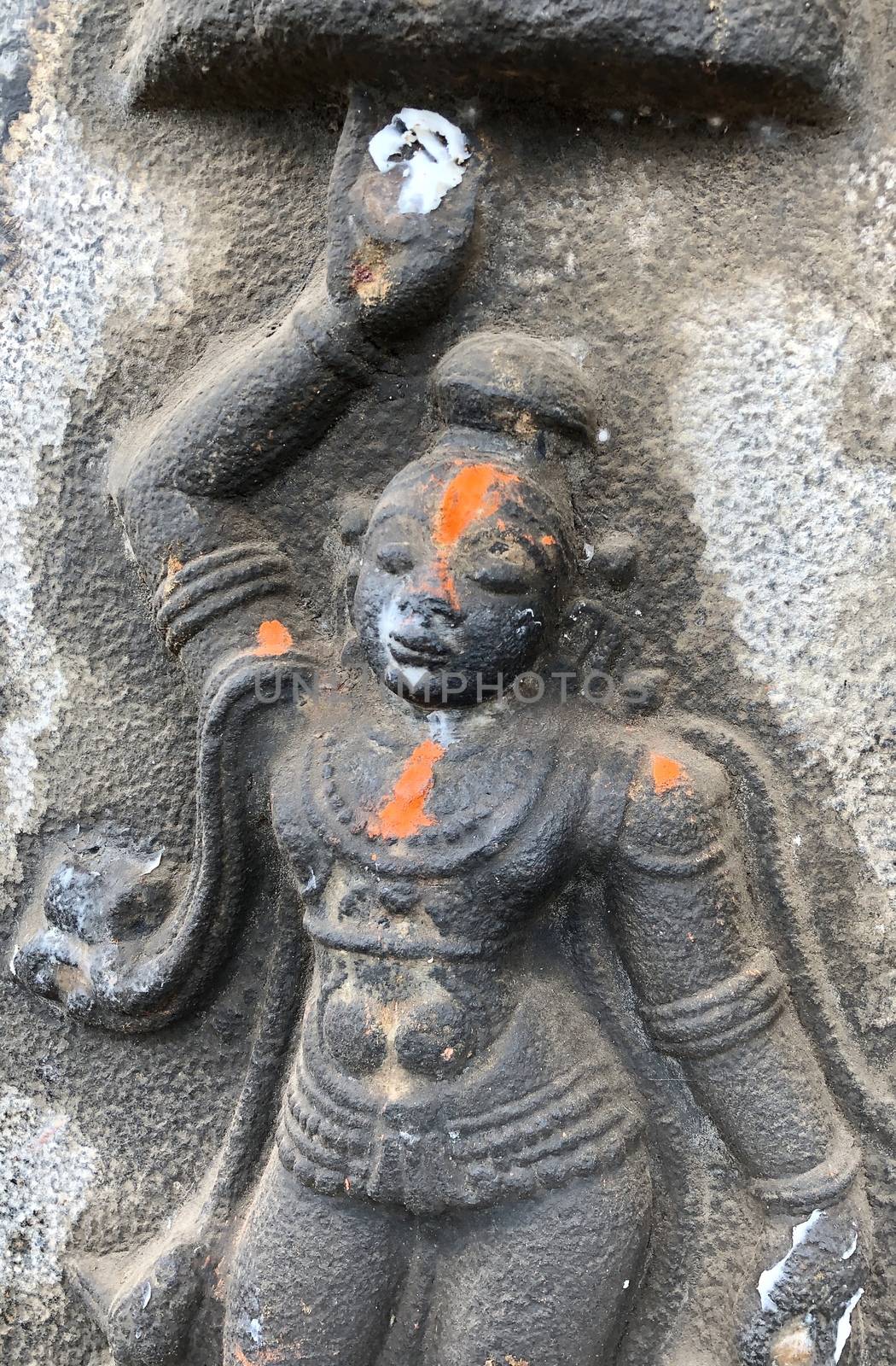Sculpture of God Krishna holding the mountain. Bas relief sculpture carved in the stone wall of Shiva temple, Tamil nadu by prabhakaran851