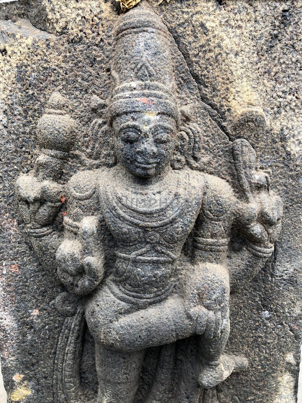 Hindu God sculpture with four hands. Bas relief sculpture carved in the stone wall of Shiva temple, Tamil nadu by prabhakaran851