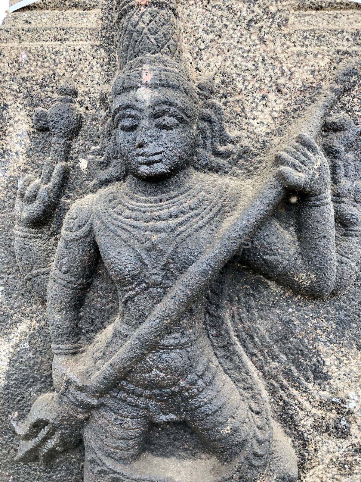 Sculpture of Shiva holding a trishula. Bas relief sculpture carved in the stone wall of Shiva temple in Tamil nadu by prabhakaran851