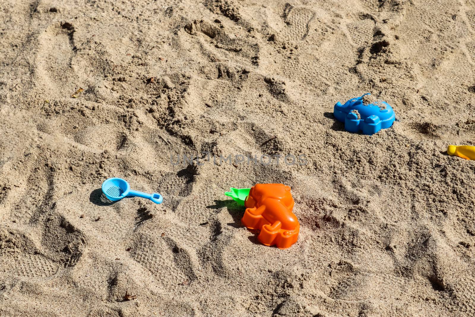 Colorful plastic children toys in sandbox at a playing ground