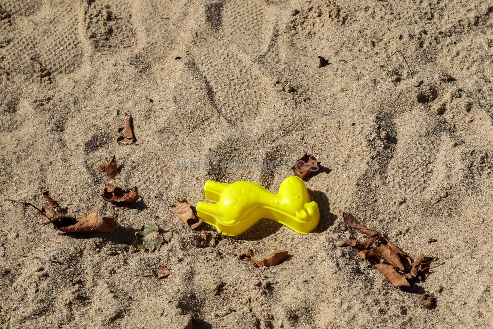 Colorful plastic children toys in sandbox at a playing ground. by MP_foto71