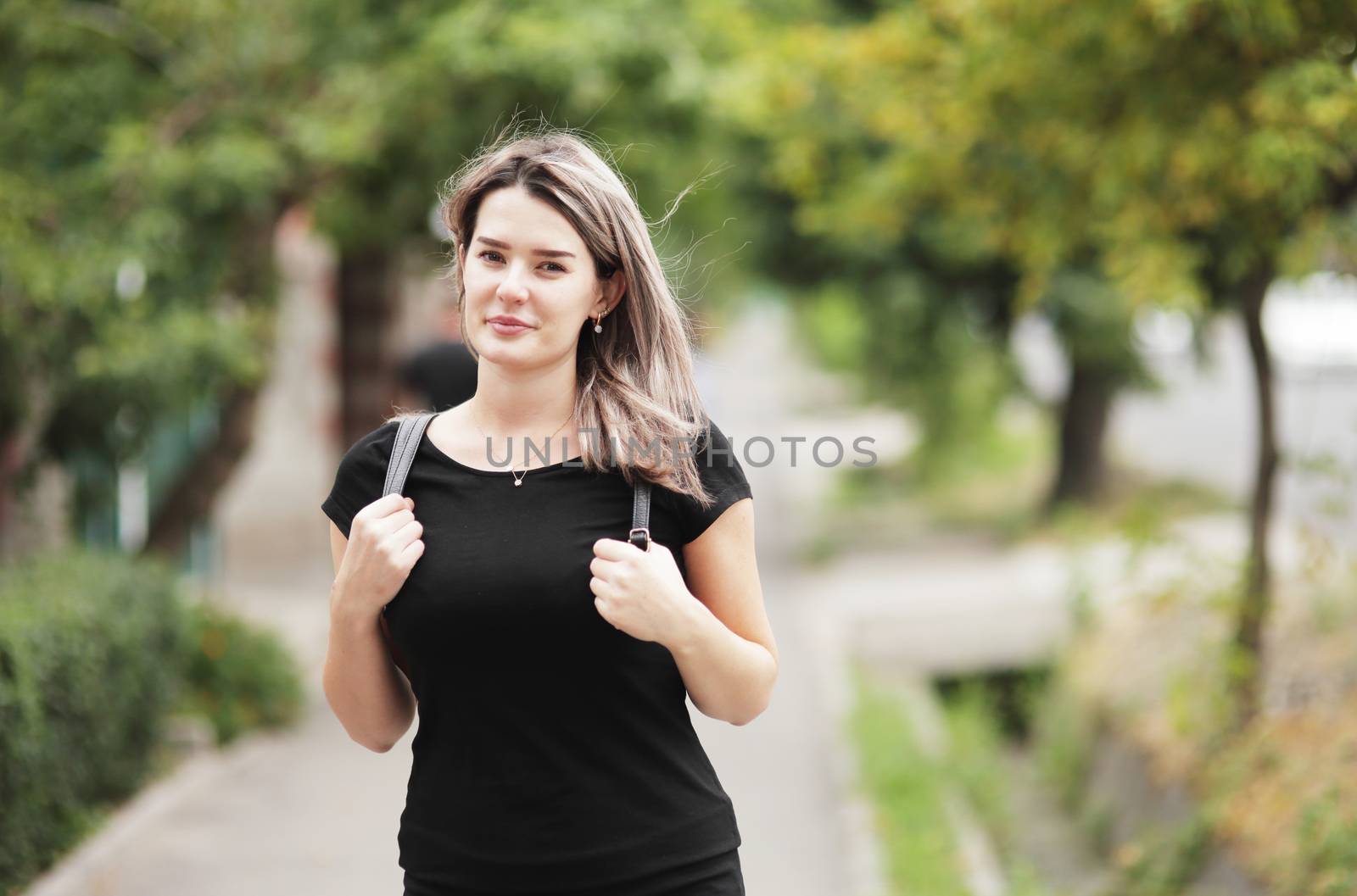 Fashion portrait of young stylish woman walking down the street, in trendy outfit, traveling with a backpack. High quality photo