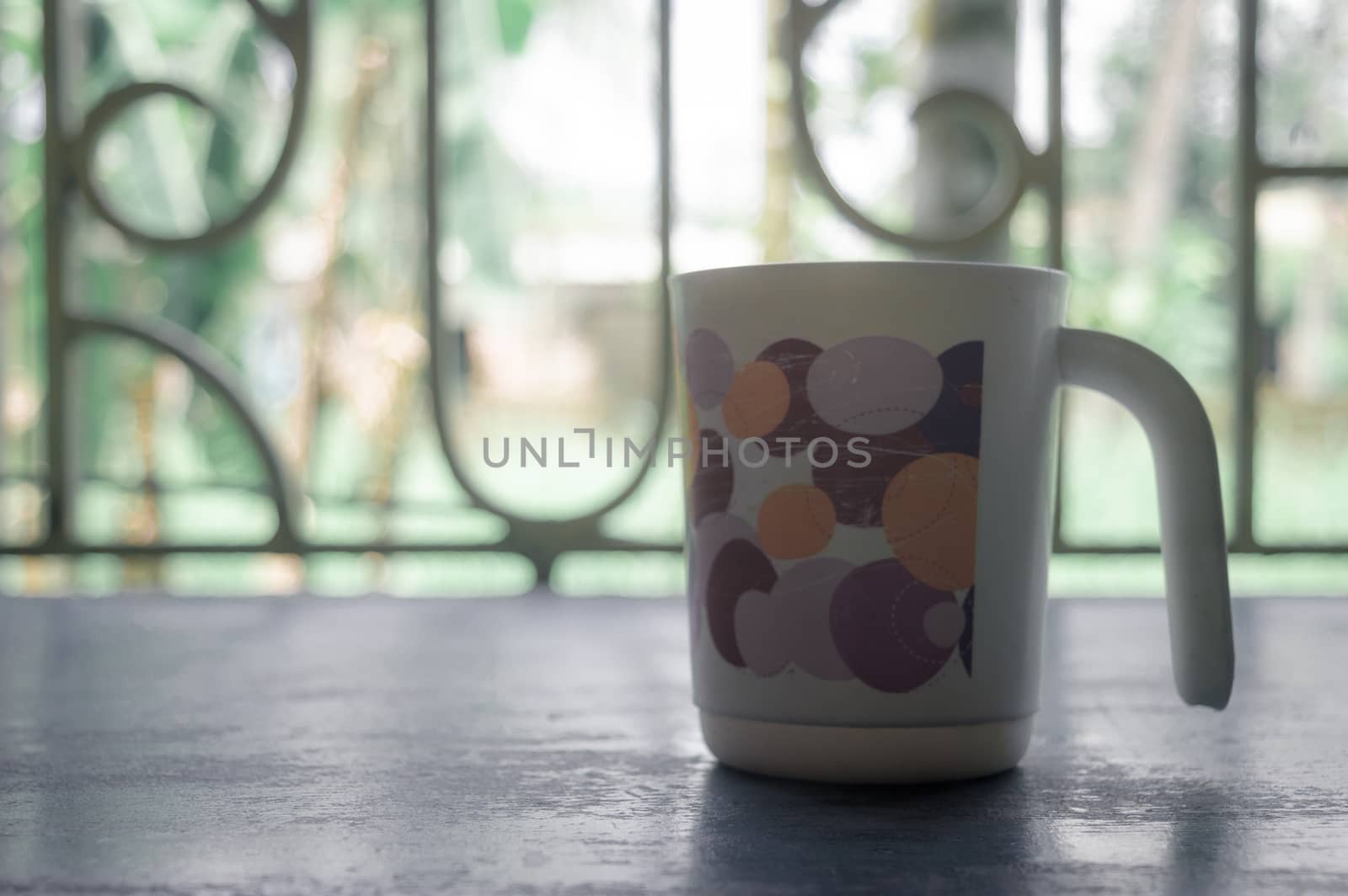 Coffee cup and window. Morning cup of coffee. Coffee cup isolated from in window sunlight in background.