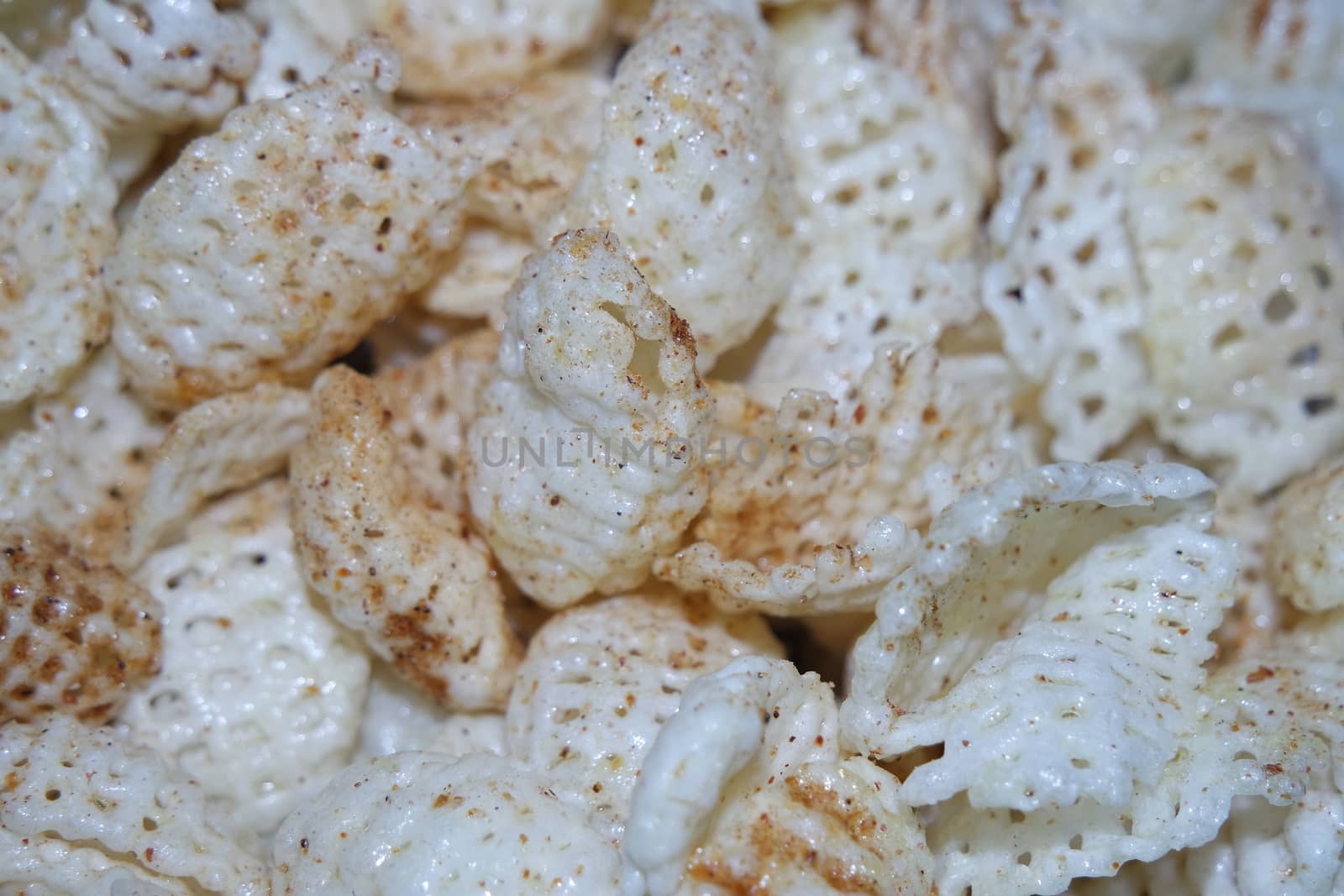 Closeup view of freshly fried chips as fast food for tea break. Potato chips with spices sprinkled on it. Fast food background for advertisements.