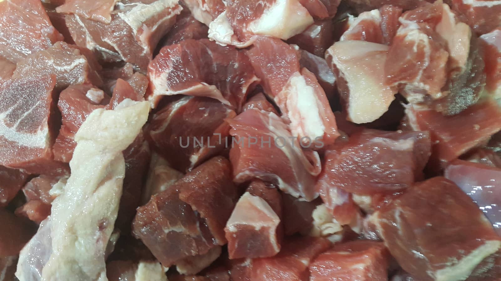 Close up view of fresh finely chopped meat cubes. Red meat small steaks with whitish meat fat.