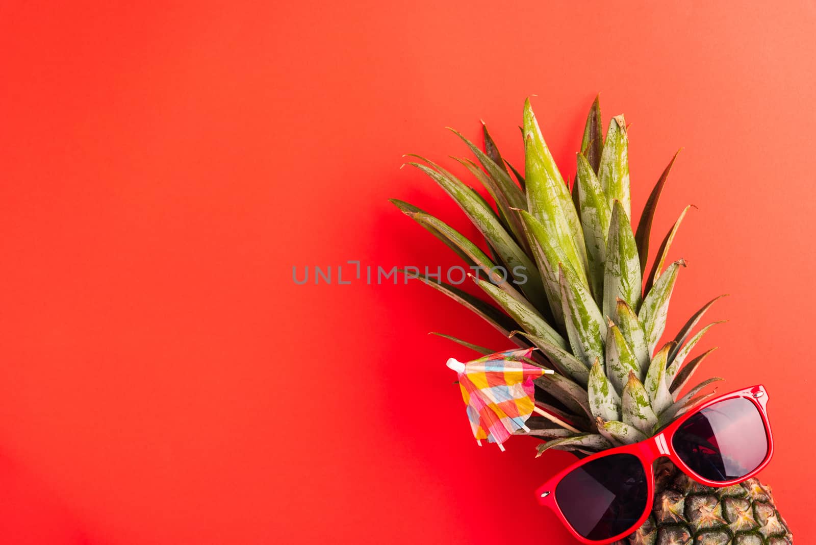 Celebrate Summer Pineapple Day Concept, Top view flat lay of funny pineapple wear red sunglasses, studio shot isolated on red background, Holiday summertime in tropical, minimal stylish fruit