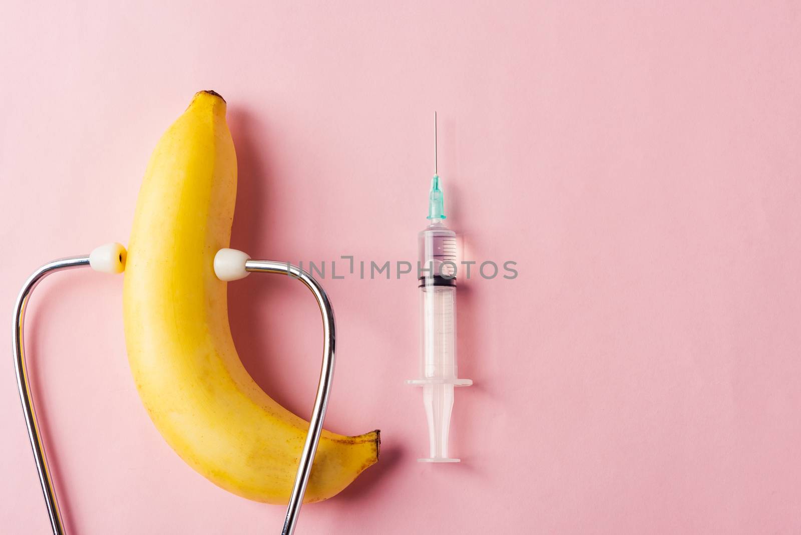 World sexual health or Aids day, Top view flat lay condom in wrapper pack, syringe and doctor stethoscope, studio shot isolated on a pink background, Safe sex and reproductive health concept