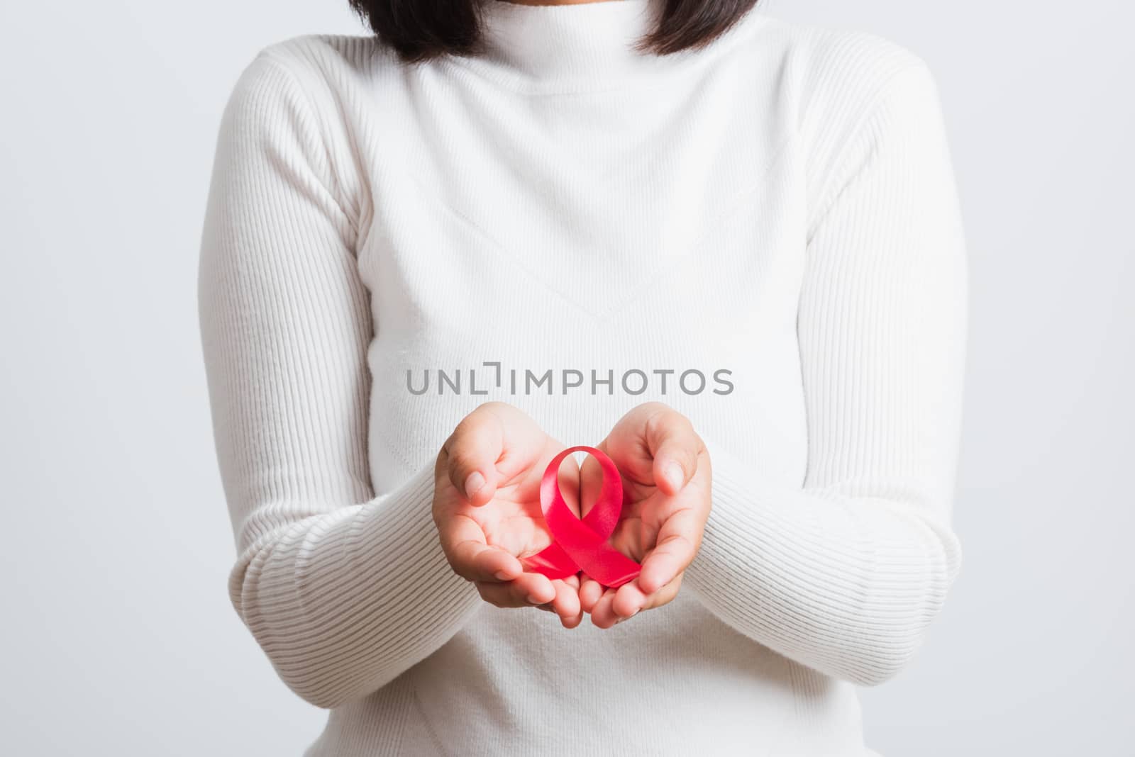 Breast cancer awareness healthcare and medicine concept. Close up Asian woman holding pink breast cancer awareness ribbon on hands treatment charity, studio shot isolated on white background