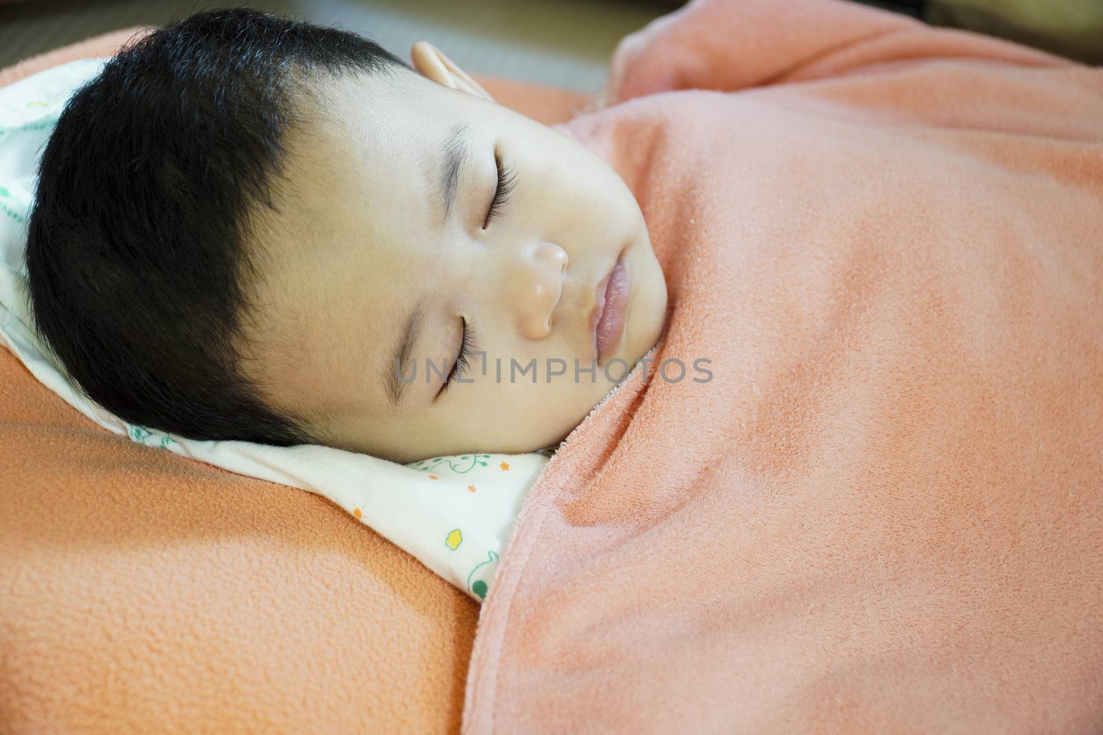 Close-up of a baby sleeping in bed.