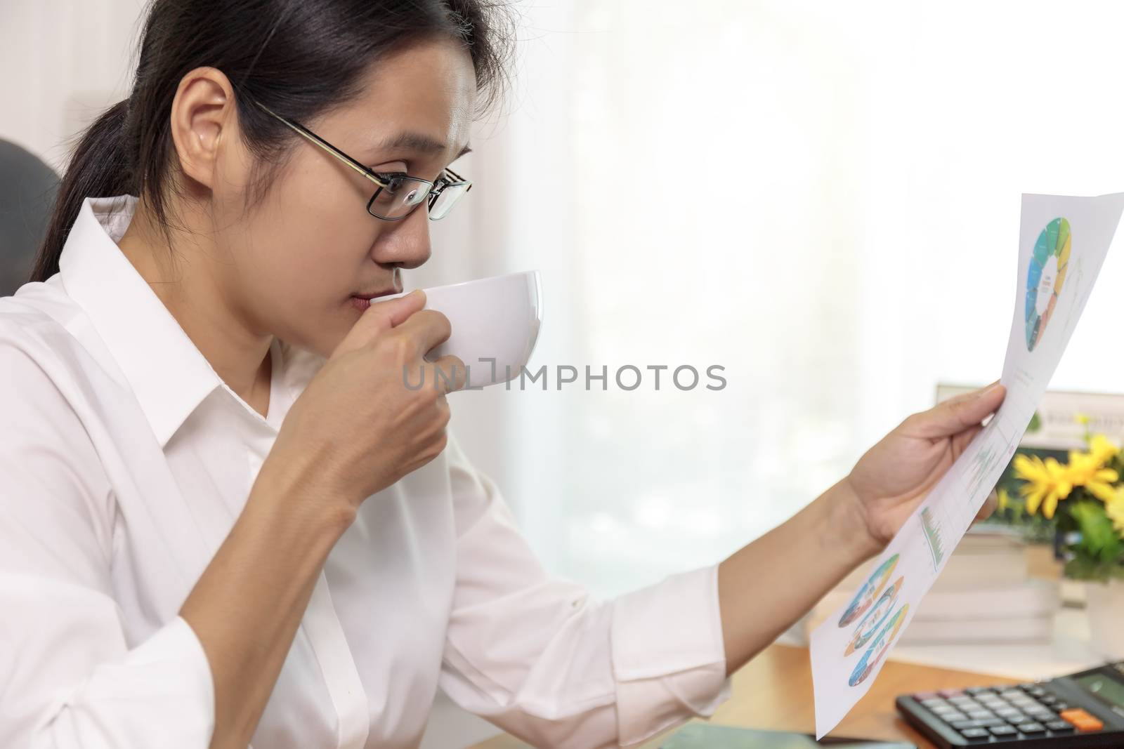 Close up Asian business women working at home analysis report chart. Business people looking workplan paper on hand.