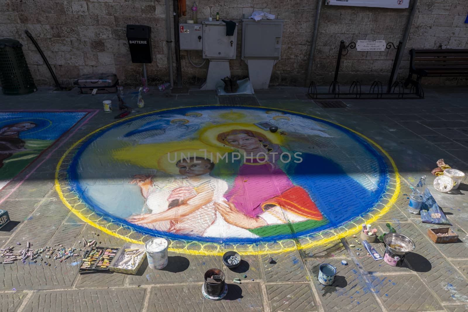 gubbio,italy august 29 2020:street artist and his works drawn on the ground