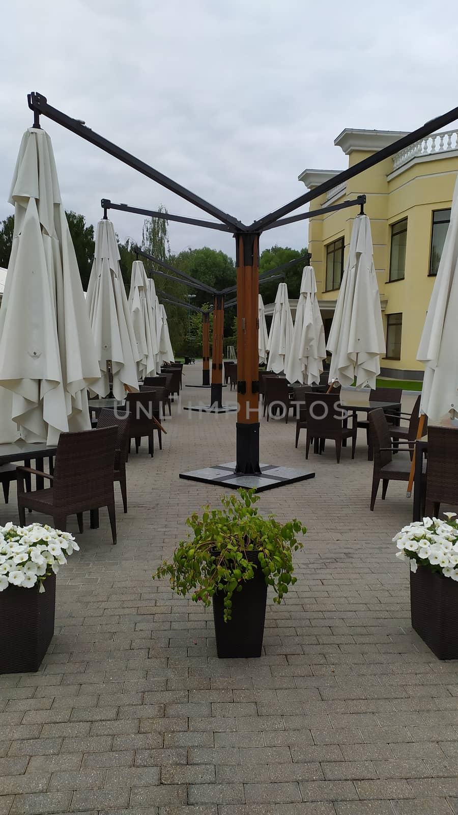 outdoor cafe prepared for the rain. Removed the chairs, rolled up the canopy