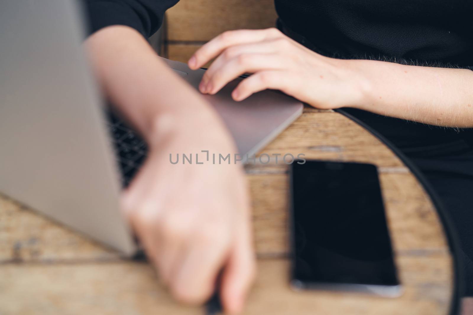 Laptop on table mobile phone female hands work cropped view of freelancer. High quality photo