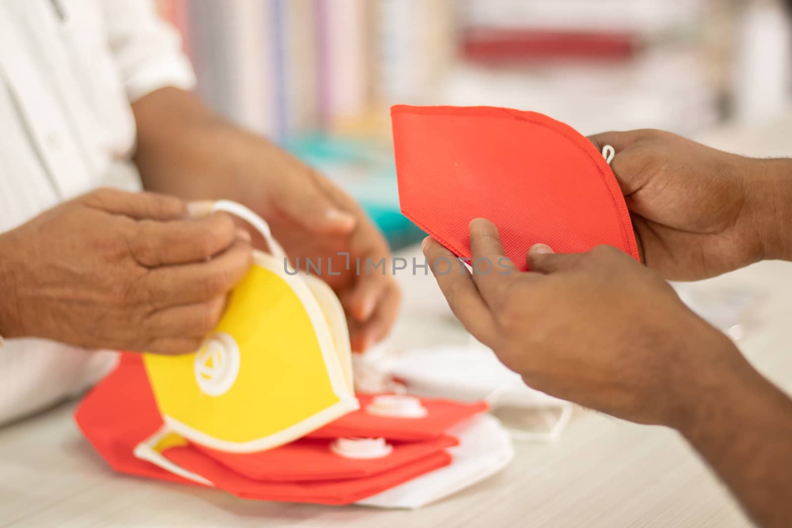 Close up of Shopkeeper hands selling masks to buyer during coronavirus or covid-19 pandemic - concept of buy local or support local during financial crisis. by lakshmiprasad.maski@gmai.com