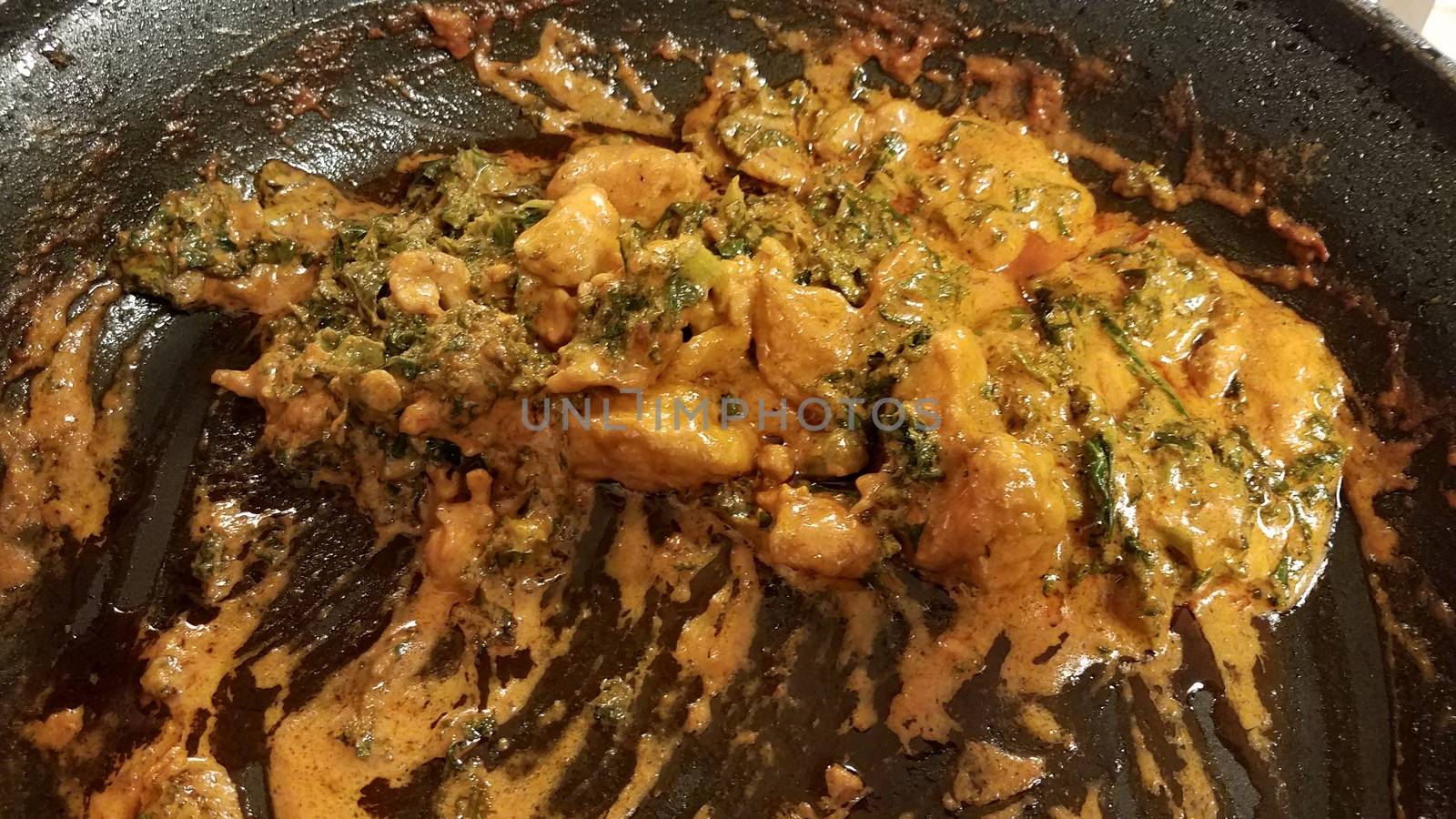 chicken and kale with sauce or gravy in skillet