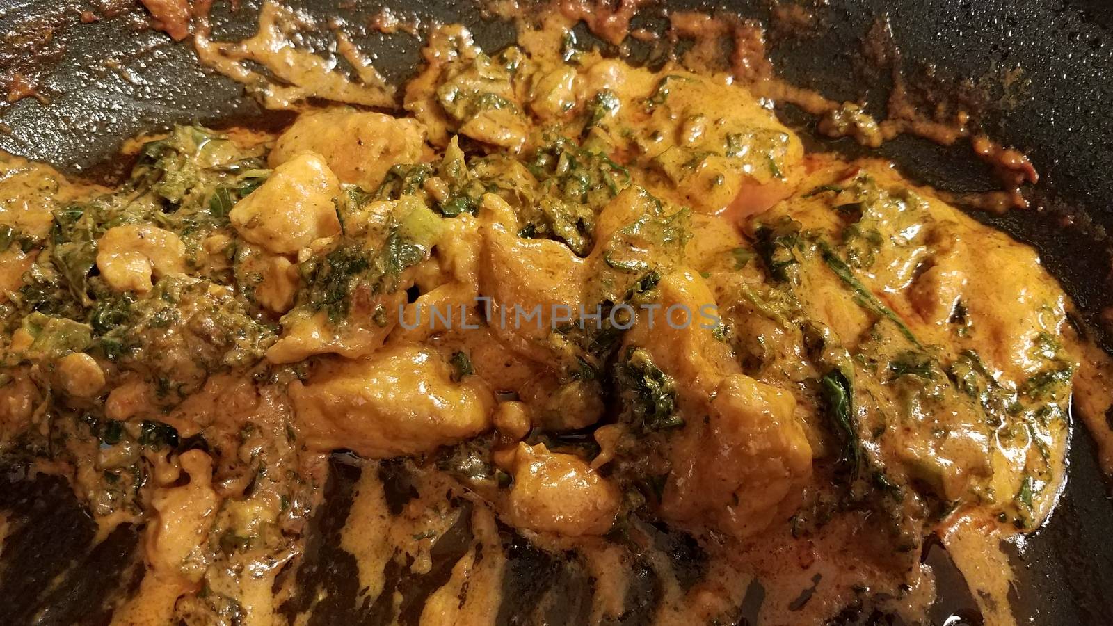 chicken and kale with sauce or gravy in skillet